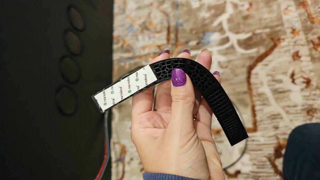Underside of the Nanoleaf 4D corner bracket showing the tape attached.