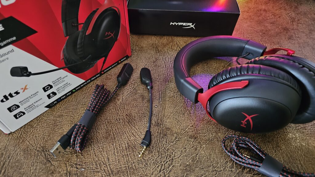 Unboxing the HyperX Cloud III wired headset showing the headset with a wired, detachable microphone, and USB cable.
