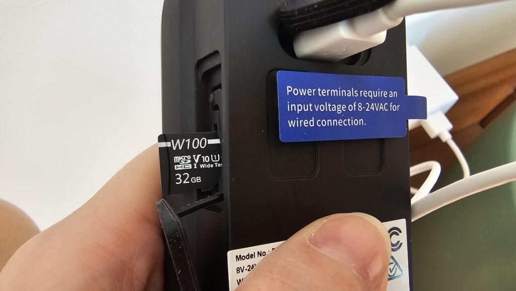 SD card sticking out of the video doorbell. There's a sticker on the terminals saying "power terminals require an input voltage of 8-25VAC for wired connection".