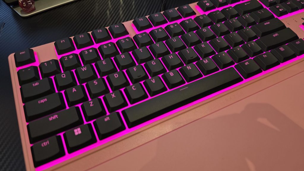 Top angle shot of the keyboard showing the beautiful pink lighting and wrist rest.